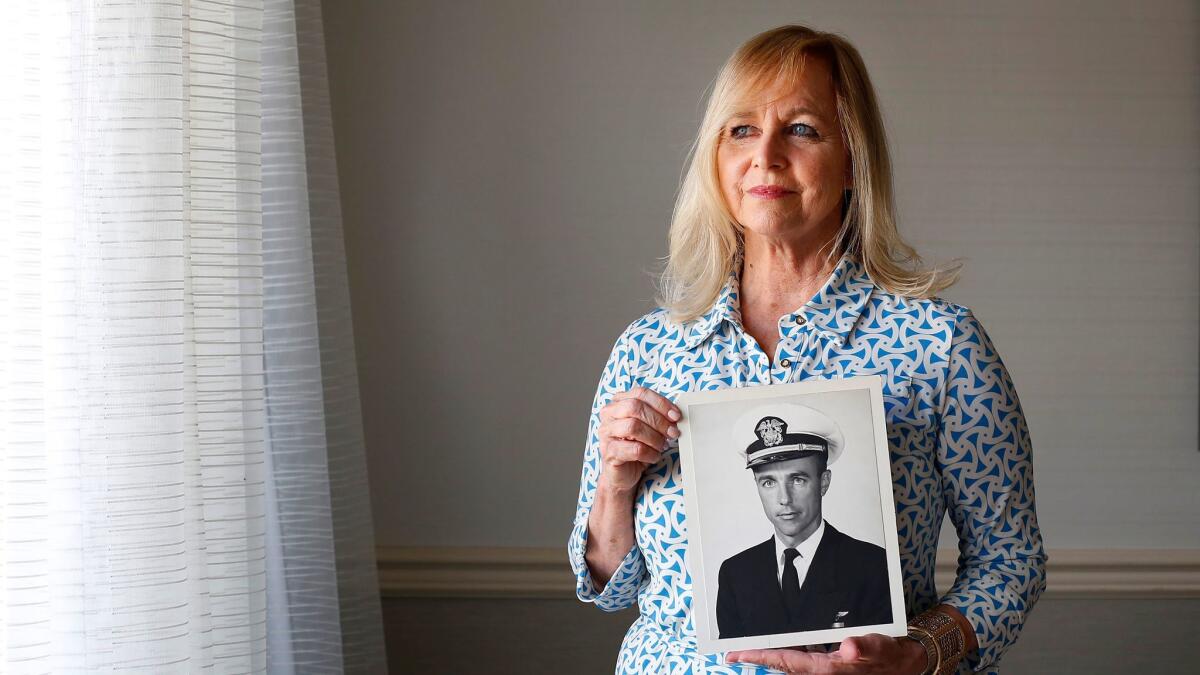 Deborah Crosby, 58, holds a photo of her father, Navy pilot Lt. Cmdr. Frederick Crosby. Deborah Crosby is in San Diego to greet her father's casket on Friday, as his remains will be returned from North Vietnam after more than 50 years.