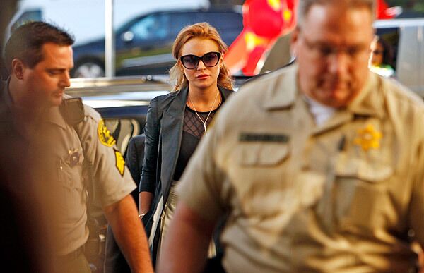 Lindsay Lohan is accompanied by sheriff's deputies into the Beverly Hills courthouse, where a judge ordered her to be taken into custody without bail.