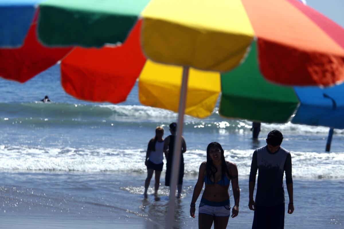 Couples enjoy a sunny day at Venice Beach in March.