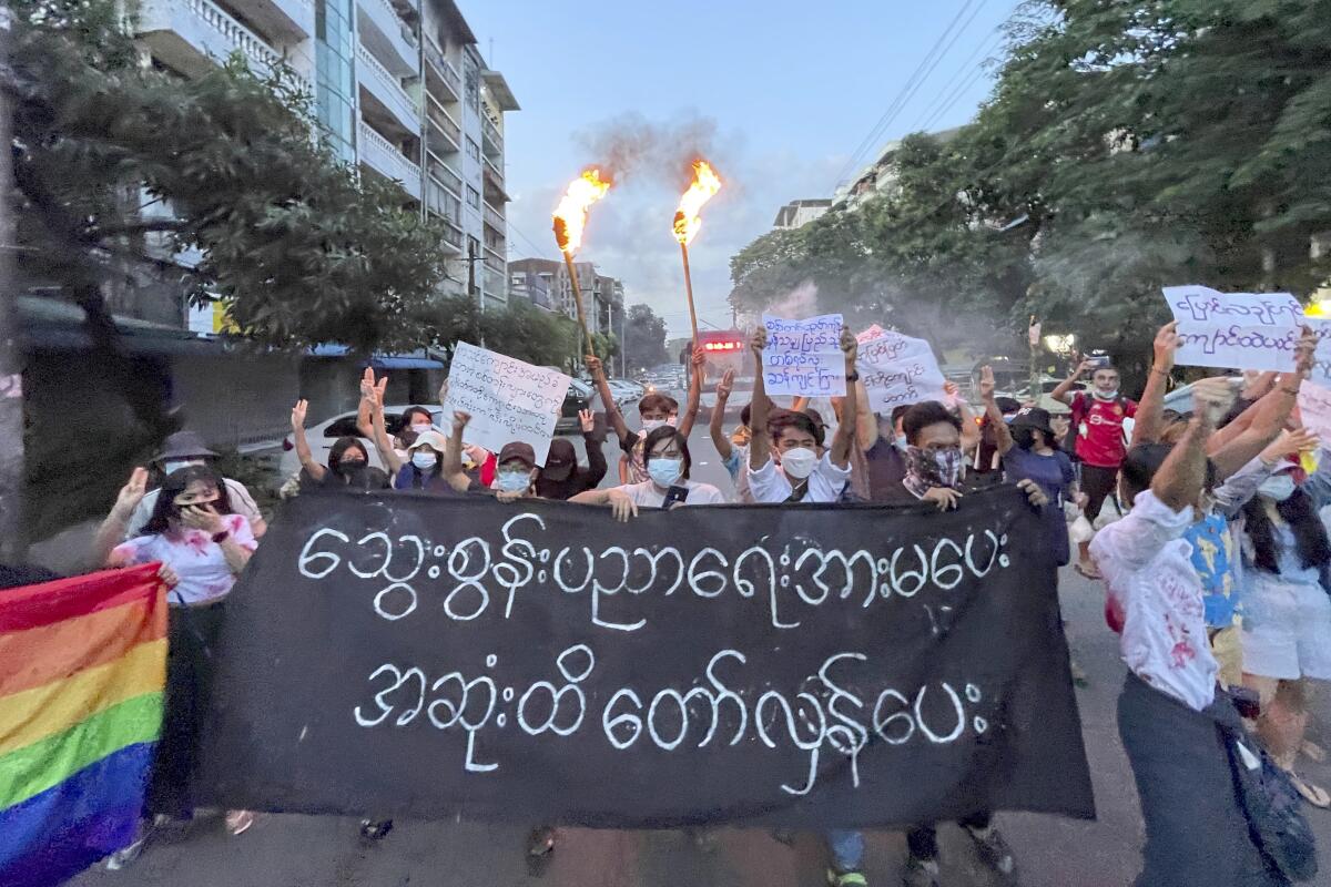 A small group of protesters hold a banner which reads in Burmese 'Do not support the bloody education, revolt until the end' while calling for a boycott of the education system under the military government that ousted Myanmar leader Aung San Suu Kyi, during a flash mob rally in Tarmwe township in Yangon, Myanmar, Wednesday, Nov. 10, 2021. (AP Photo)