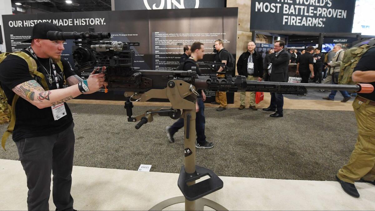 Kenneth Conkright of Colorado looks at a .50-caliber M2 machine gun at the Shooting, Hunting, Outdoor Trade Show in Las Vegas.