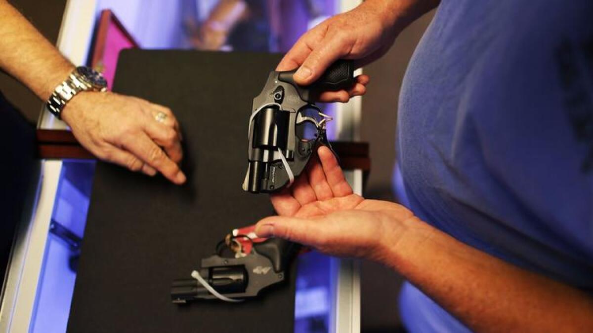 A customer shops for a handgun, which will be banned from California school campuses.