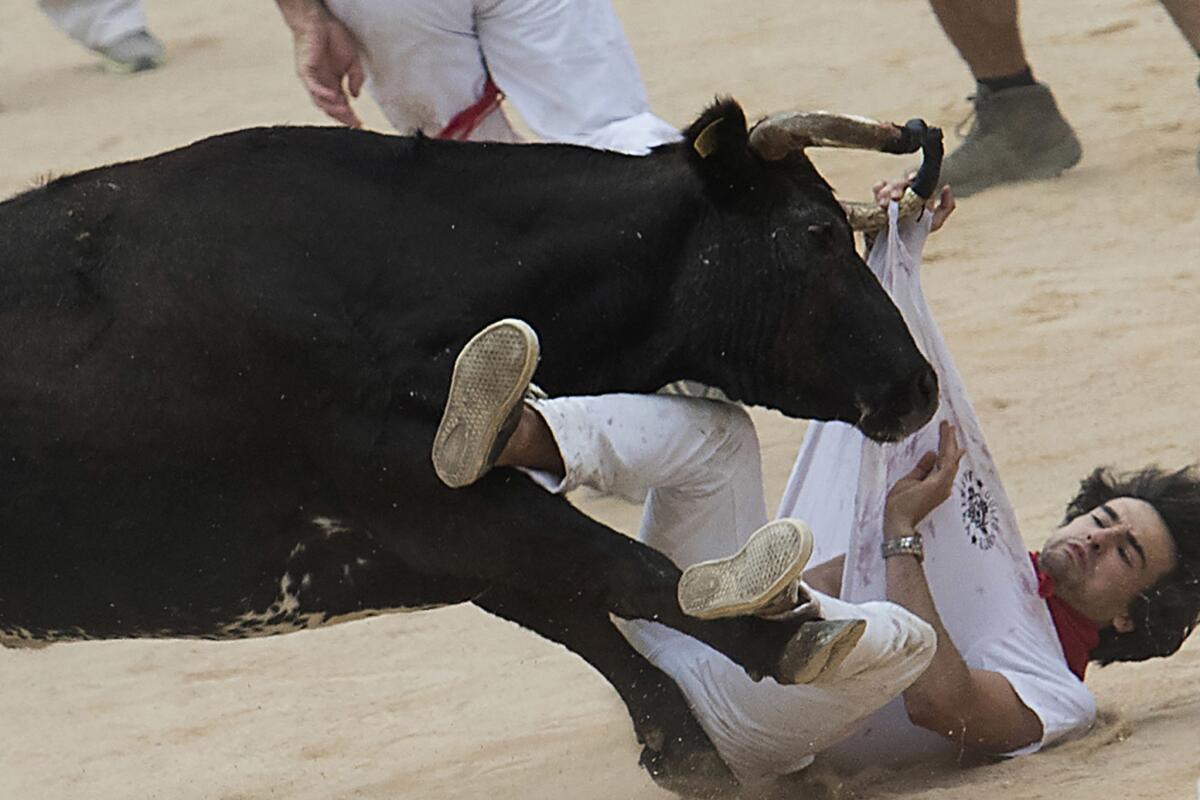 A participant is tossed by a heifer bull during a bullrun in Pamplona. (Jaime Reina / AFP / Getty Images)