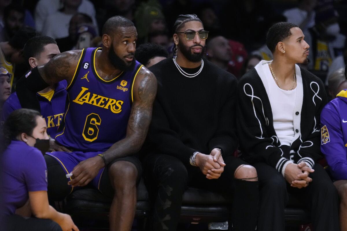 LeBron James, left, sits next to injured teammates Anthony Davis and Juan Toscano-Anderson.
