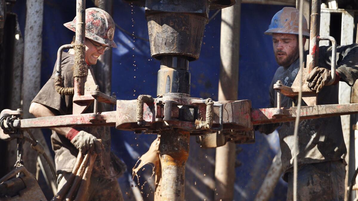 Oil workers near Medicine Lodge, Kan. (Orlin Wagner / Associated Press)