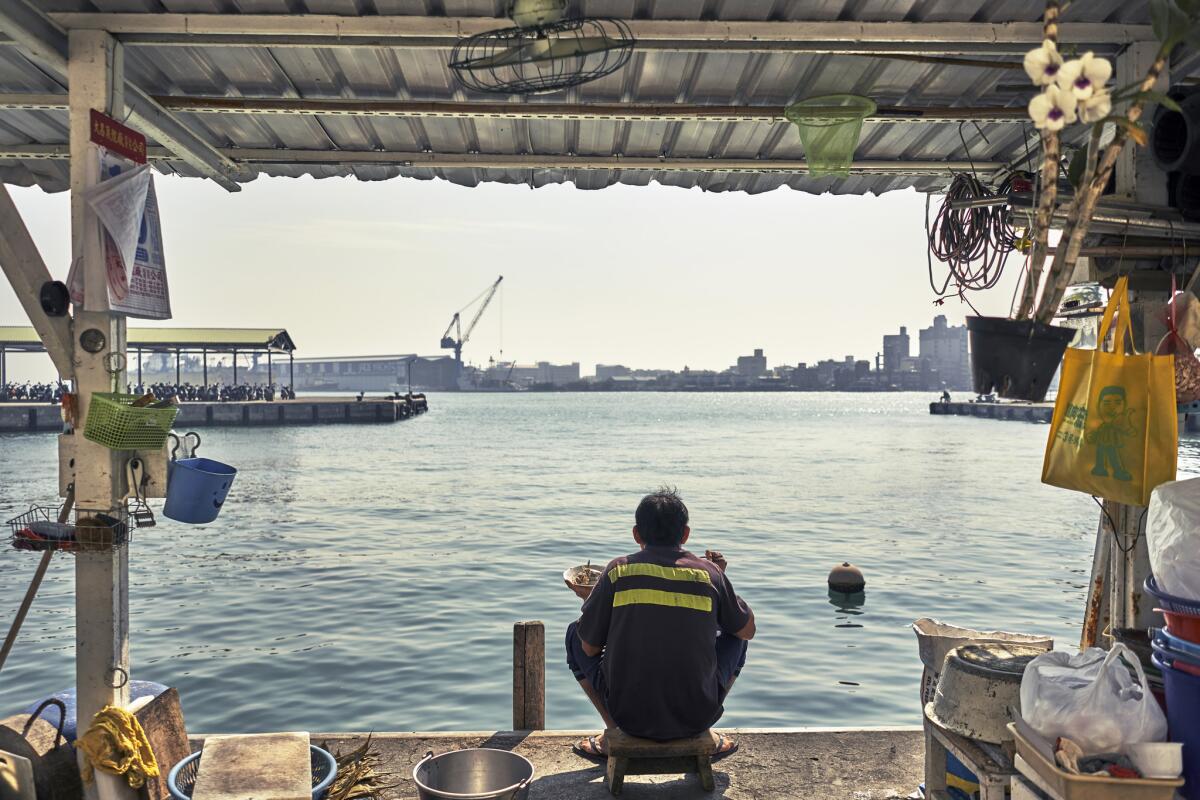 A Kaohsiung local sits on the harbor in Kaohsiung, once one of the world's top 10 shipping ports. As manufacturing moved overseas to China in the 1990s, much of Kaohsiung's wealth and business disappeared.