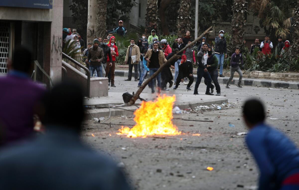 Pro- and anti-government protesters throw stones during clashes near Tahrir Square in Cairo.