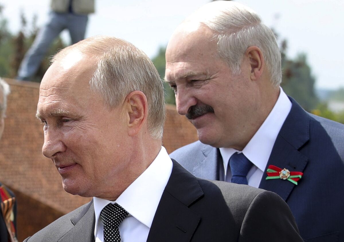 FILE - In this June 30, 2020, file photo, Russian President Vladimir Putin, left, and Belarusian President Alexander Lukashenko greet World War II veterans during the opening of a monument in their honor in the village of Khoroshevo northwest of Moscow, Russia. As Belarus experiences spasms of protests and a brutal police crackdown, its giant neighbor Russia has been uncharacteristically low key in response. (Mikhail Klimentyev, Sputnik, Kremlin Pool Photo via AP, File)