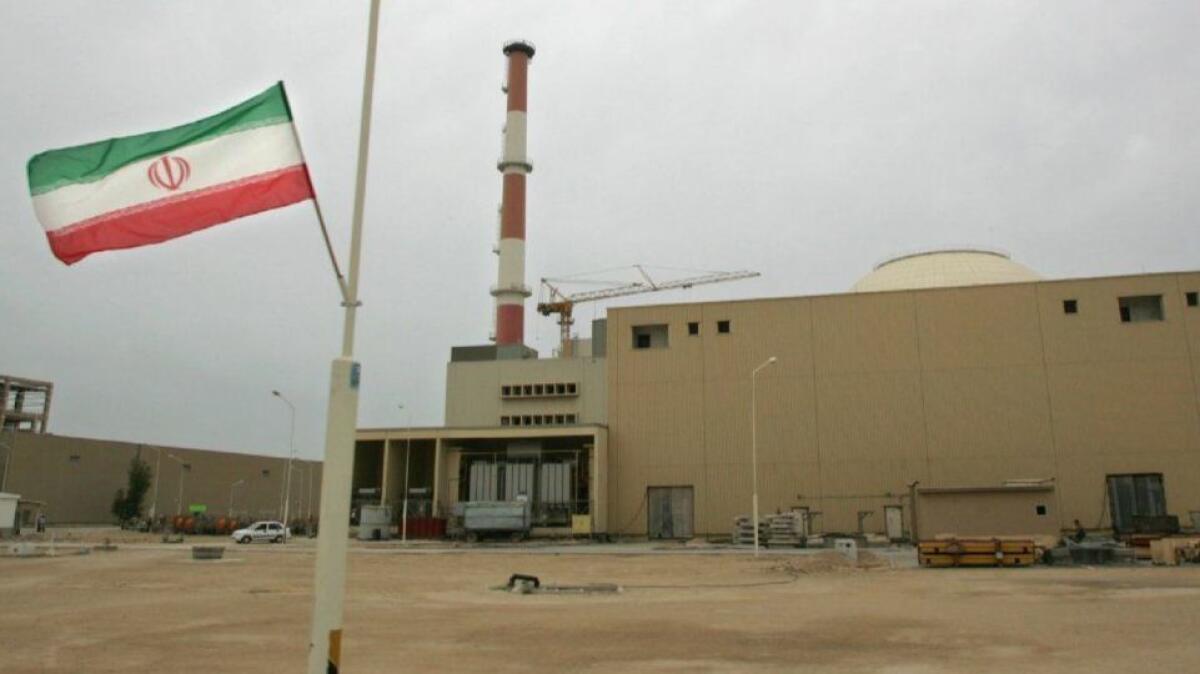 An Iranian flag flutters outside the building housing the reactor at the Bushehr nuclear power plant in 2007.