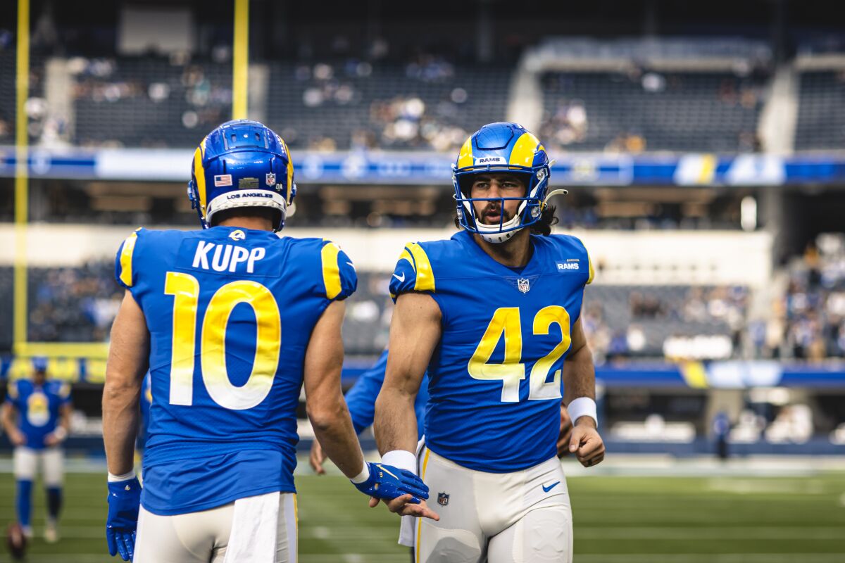 The Rams' Matt Orzech (42) and Cooper Kupp cross paths as the long snapper heads to the sideline.