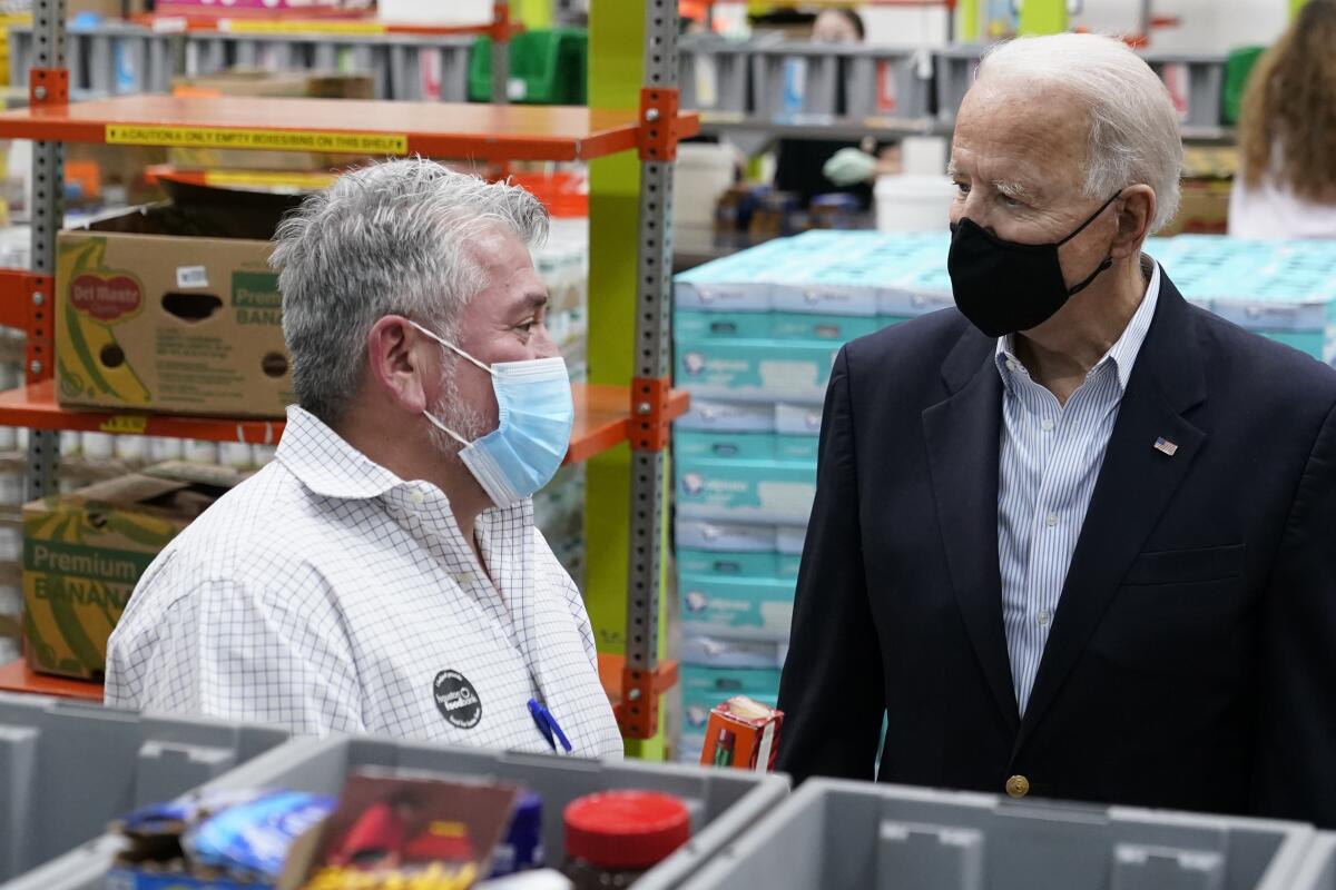 El presidente Joe Biden conversa con un voluntario en el Banco de Alimentos de Houston.