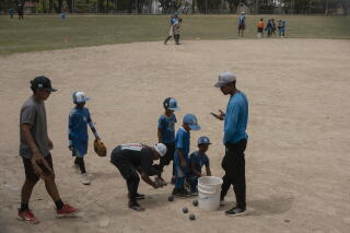 Students of the little league team for the Los Angeles de Baruta school practice in a park in Caracas.