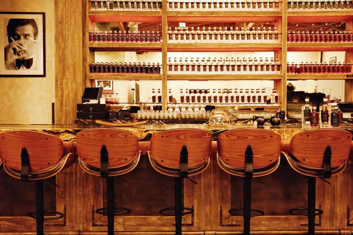 Backs of wooden bar stools line the bar at Hollywood Distillery