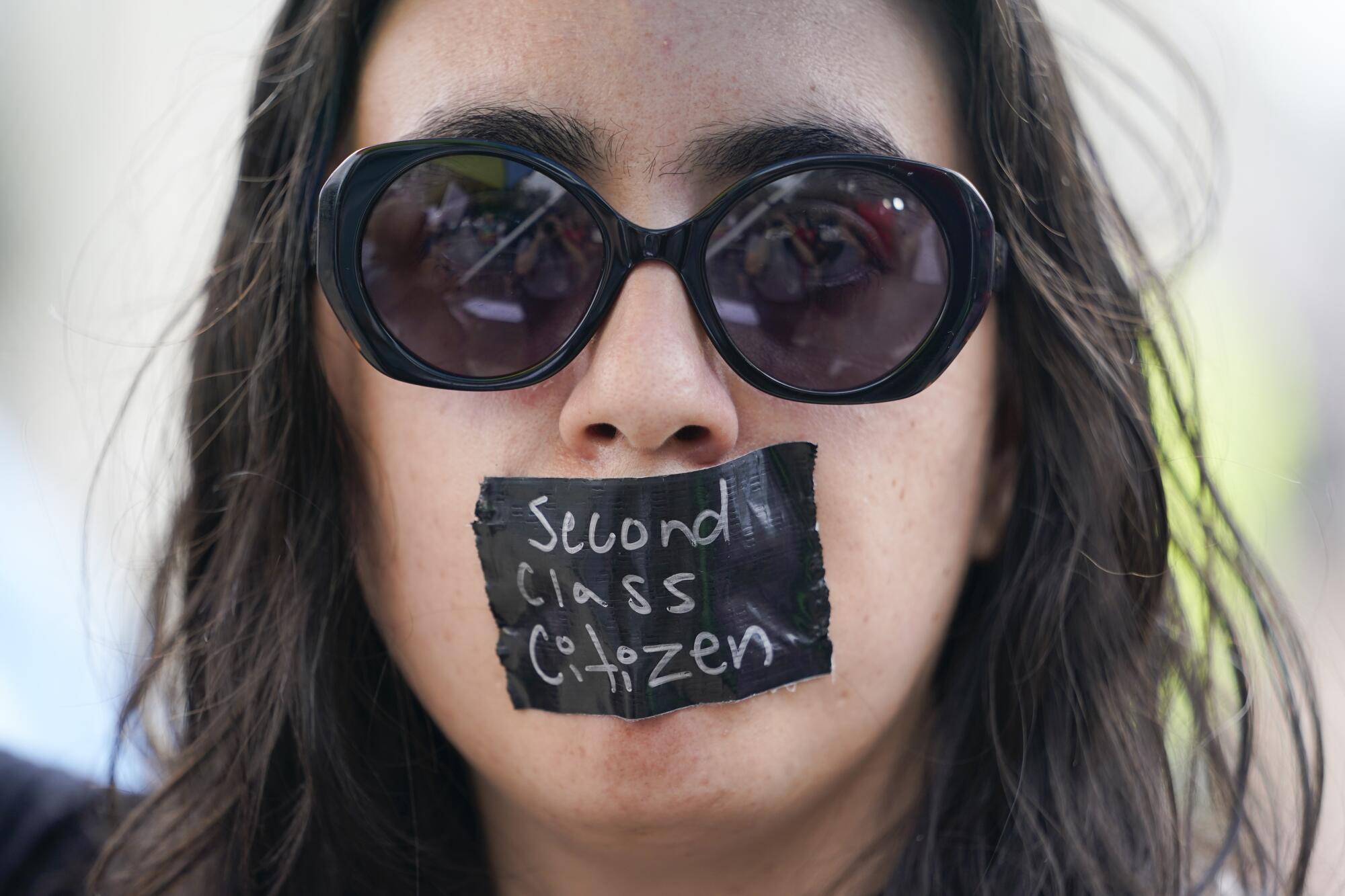An abortion rights activist wears tape reading "second class citizen"  outside the Supreme Court in Washington