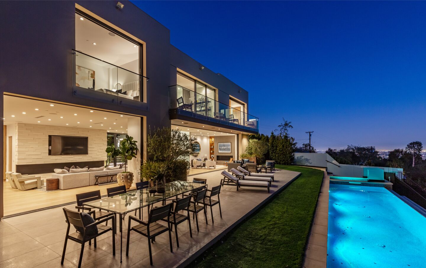 The back patio has furniture between the house and a long pool.