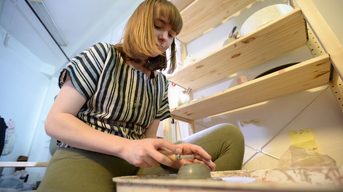 Staff writer Sara Butler attempting to make a ceramic on her pottery wheel