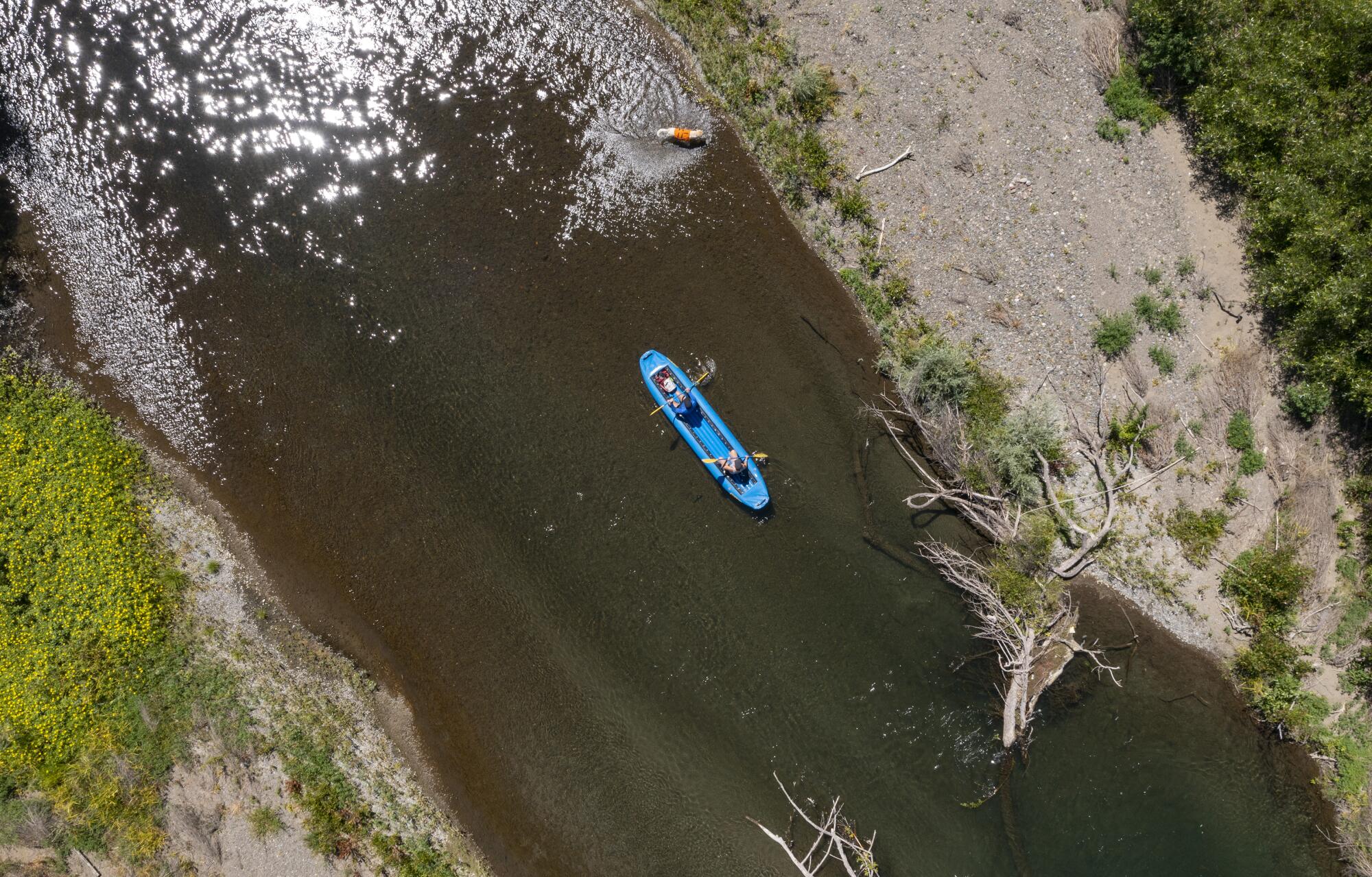 A canoe floats past an exposed gravel bar, right, on the Russian River in Healdsburg, Calif.
