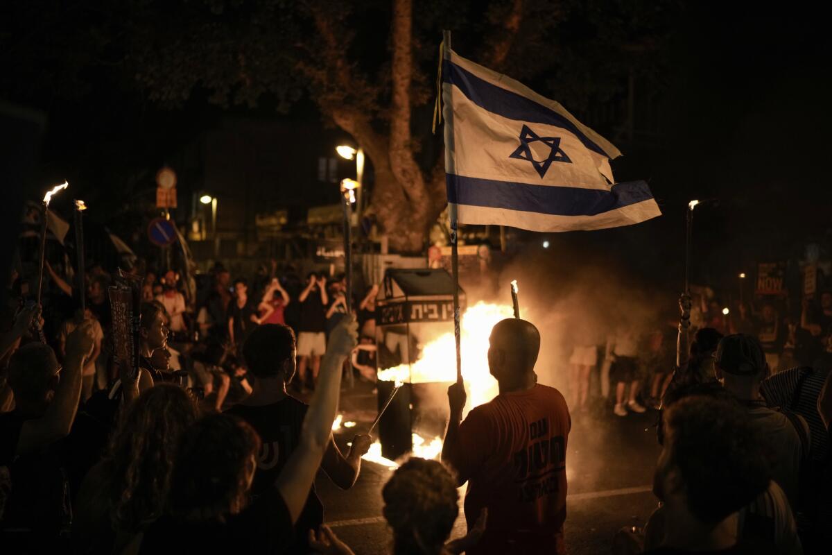 Protesters hold Israeli flags.