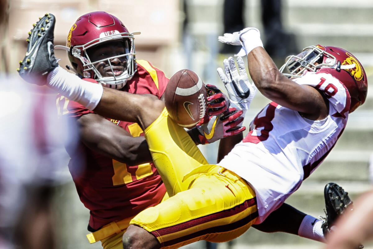 USC receiver Josh Imatorbhebhe, left, can't haul in a long pass as cornerback Jalen Jones breaks it up in the end zone during a spring practice in April.