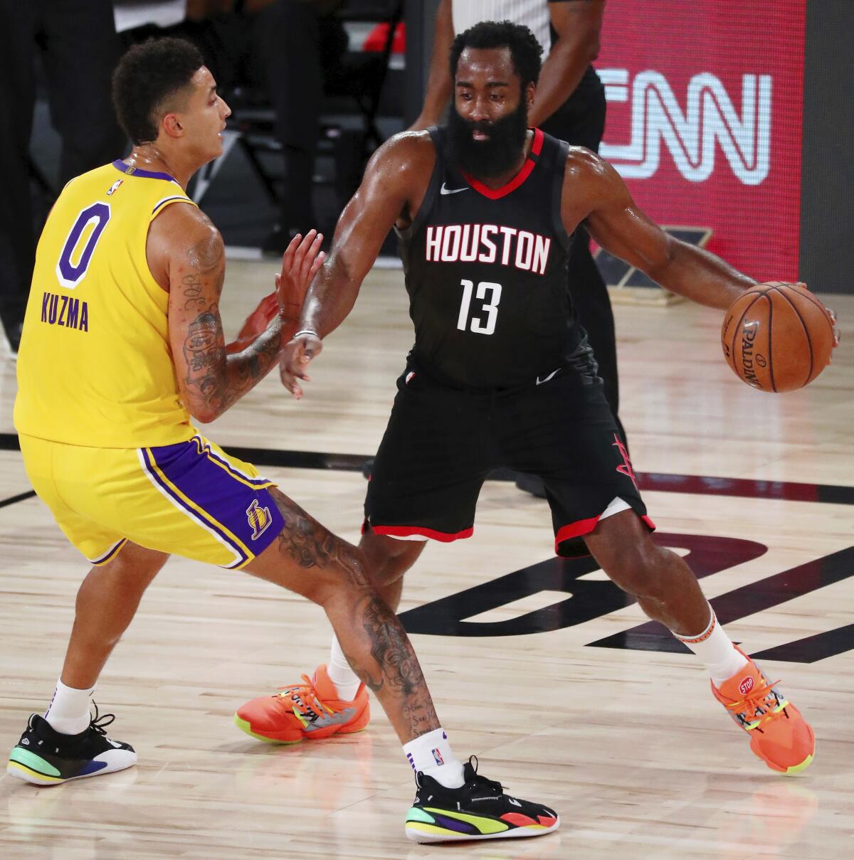 El jugador de los Rockets de Houston James Harden (13) dribla ante la defensa de su rival de los Lakers, Kyle Kuzma.