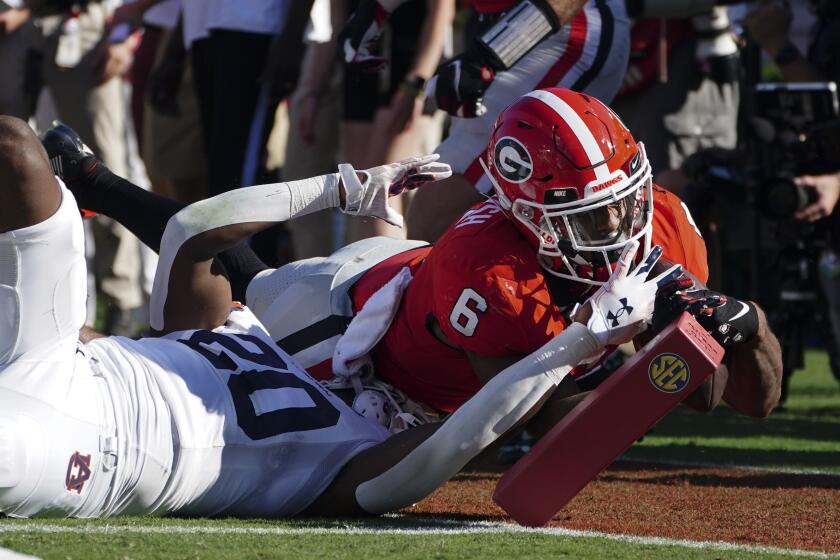 Georgia running back Kenny McIntosh (6) is stopped short of the goal line by Auburn safety Cayden Bridges (20) during the first half of an NCAA college football game Saturday, Oct. 8, 2022, in Athens, Ga. (AP Photo/John Bazemore)