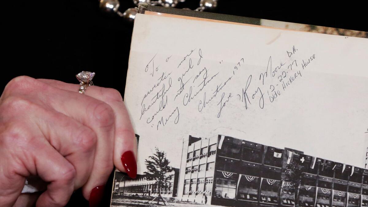 Beverly Young Nelson shows her high school yearbook purportedly signed by Roy Moore.