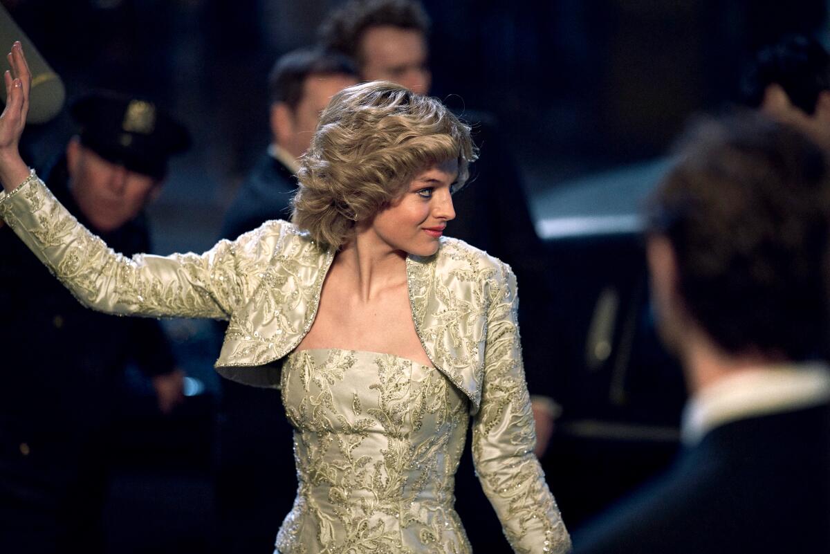Emma Corrin as Princess Diana waves and looks off to the side in "The Crown."