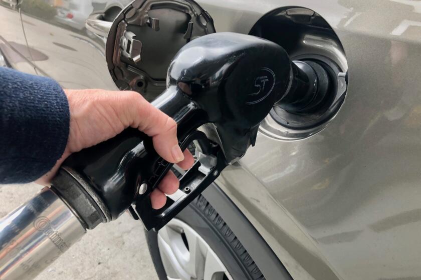 A person fills his car up with gasoline