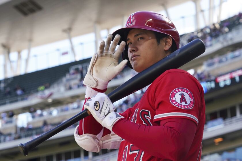 Los Angeles Angels' pitcher Shohei Ohtani (17) waves to fans as he waits on deck to bat in a baseball game against the Minnesota Twins, Sunday, Sept 25, 2022, in Minneapolis. (AP Photo/Jim Mone)