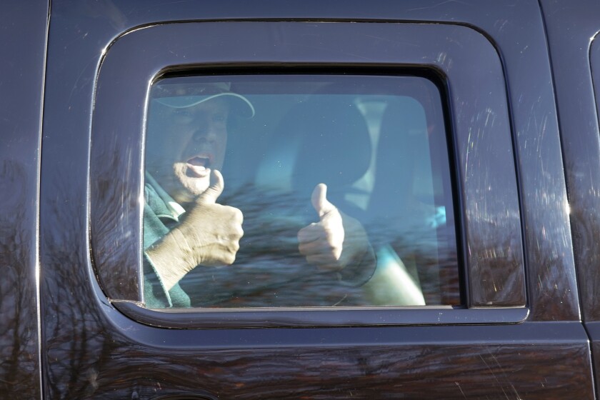 President Donald Trump gives two thumbs up to supporters as he departs after playing golf.