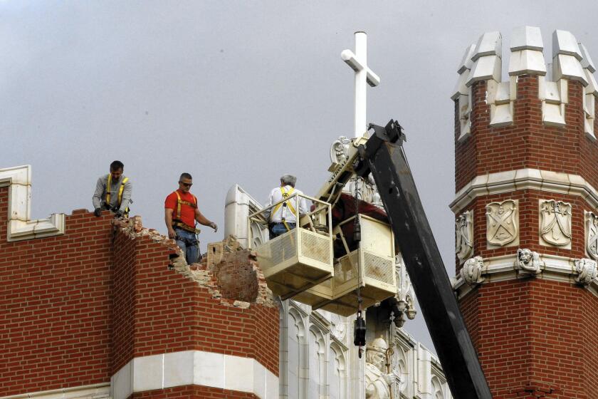 Workers inspect damage at St. Gregory's University in Shawnee, Okla., after an earthquake in 2011. The state has seen unprecedented seismic activity in recent years, which experts say is related to fracking.