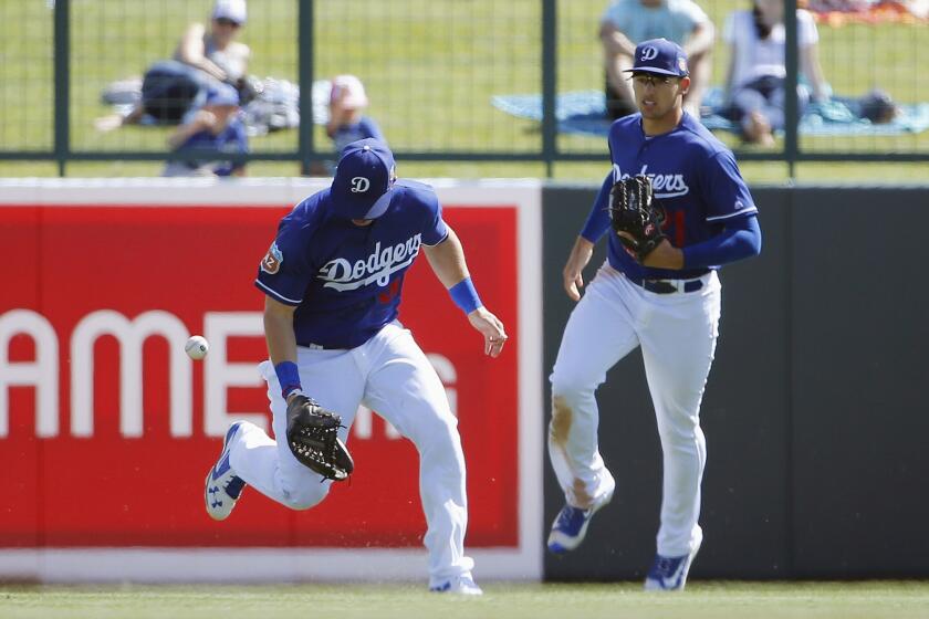 Dodgers outfielder Joc Pederson, left, drops a fly ball hit by Indians' Juan Uribe as Dodgers' Trayce Thompson, right, looks on during the fifth inning.