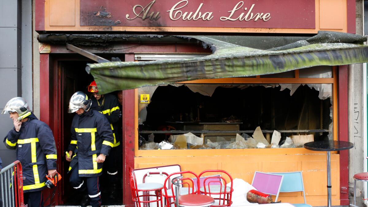 Firefighters leave the burned-out bar in Rouen, France.
