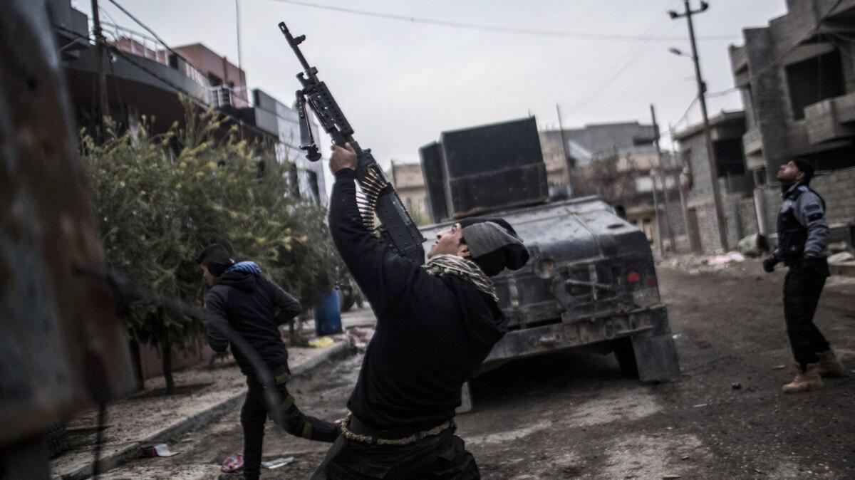 A member of the Iraqi Special Forces shoots his machine gun at an Islamic State militant drone in the al-Barid district in Mosul on Dec. 18, 2016.