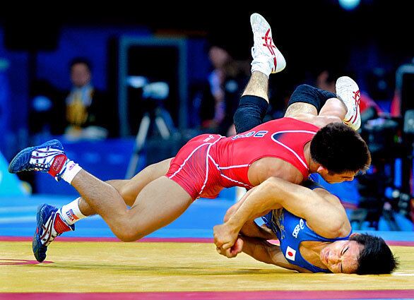 The United States' Henry Cejudo wrestles Japan's Matsunaga Tomohiro to the mat to win the gold medal in the final of men's 55-kg freestyle wrestling.