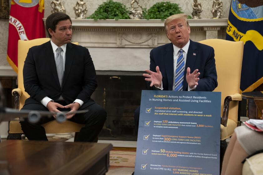 Gov. Ron DeSantis, R-Fla., listens as President Donald Trump talks about the coronavirus response during a meeting in the Oval Office of the White House, Tuesday, April 28, 2020, in Washington. (AP Photo/Evan Vucci)