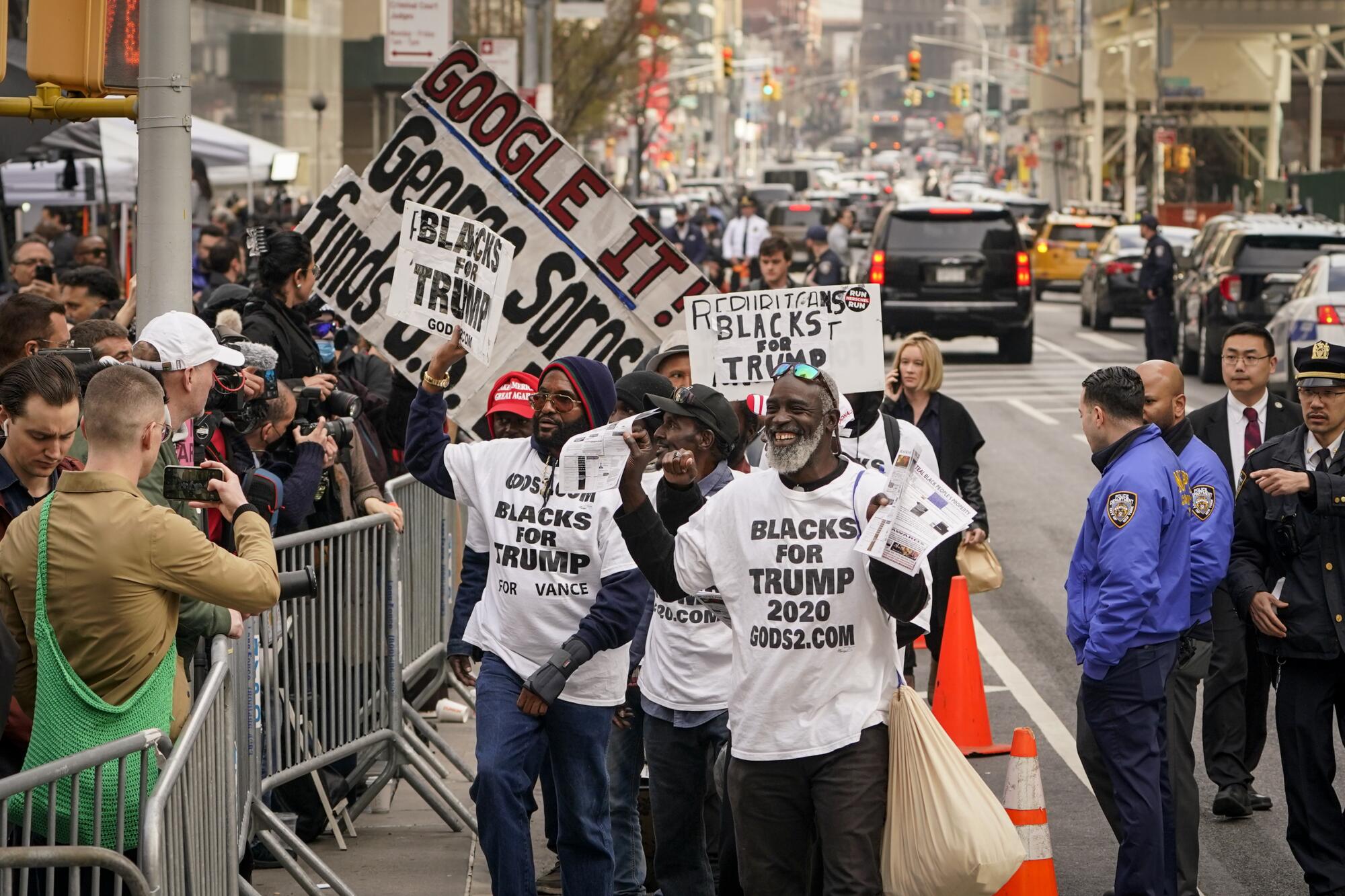 Supporters of former President Trump parade their signs outside Manhattan Criminal Court in New York.