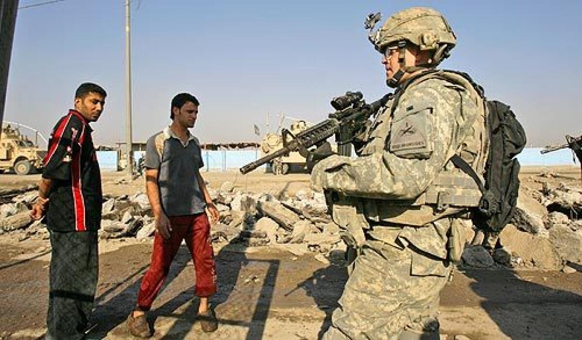 A U.S. soldier secures the area at the scene where a roadside bomb exploded in Sadr City, Iraq, on Thursday.