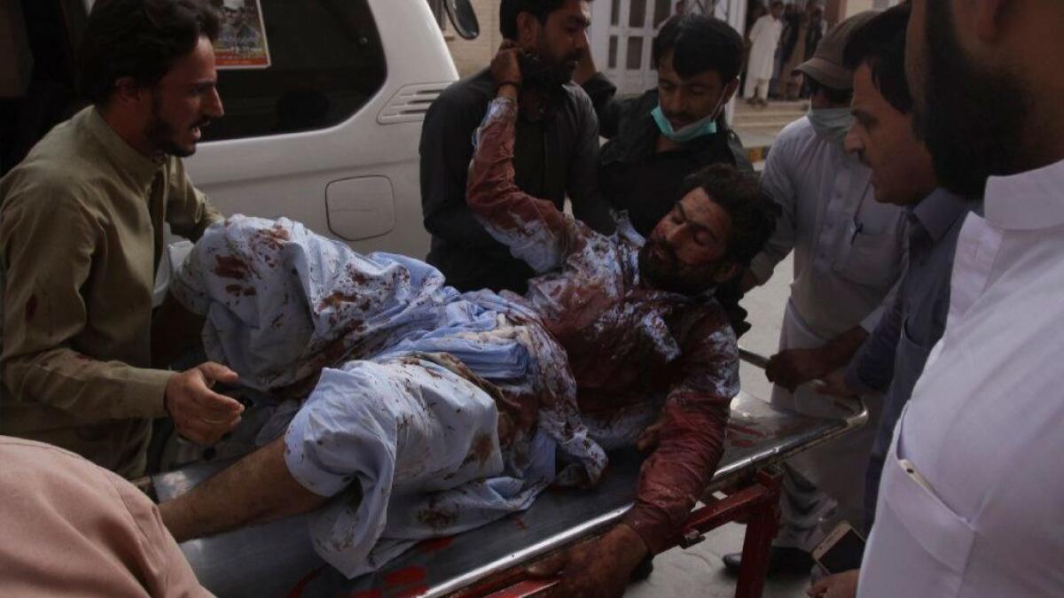 An injured man is rushed to a hospital in Quetta, Pakistan, on July 13, 2018, after a bombing at an election rally in Baluchistan province.