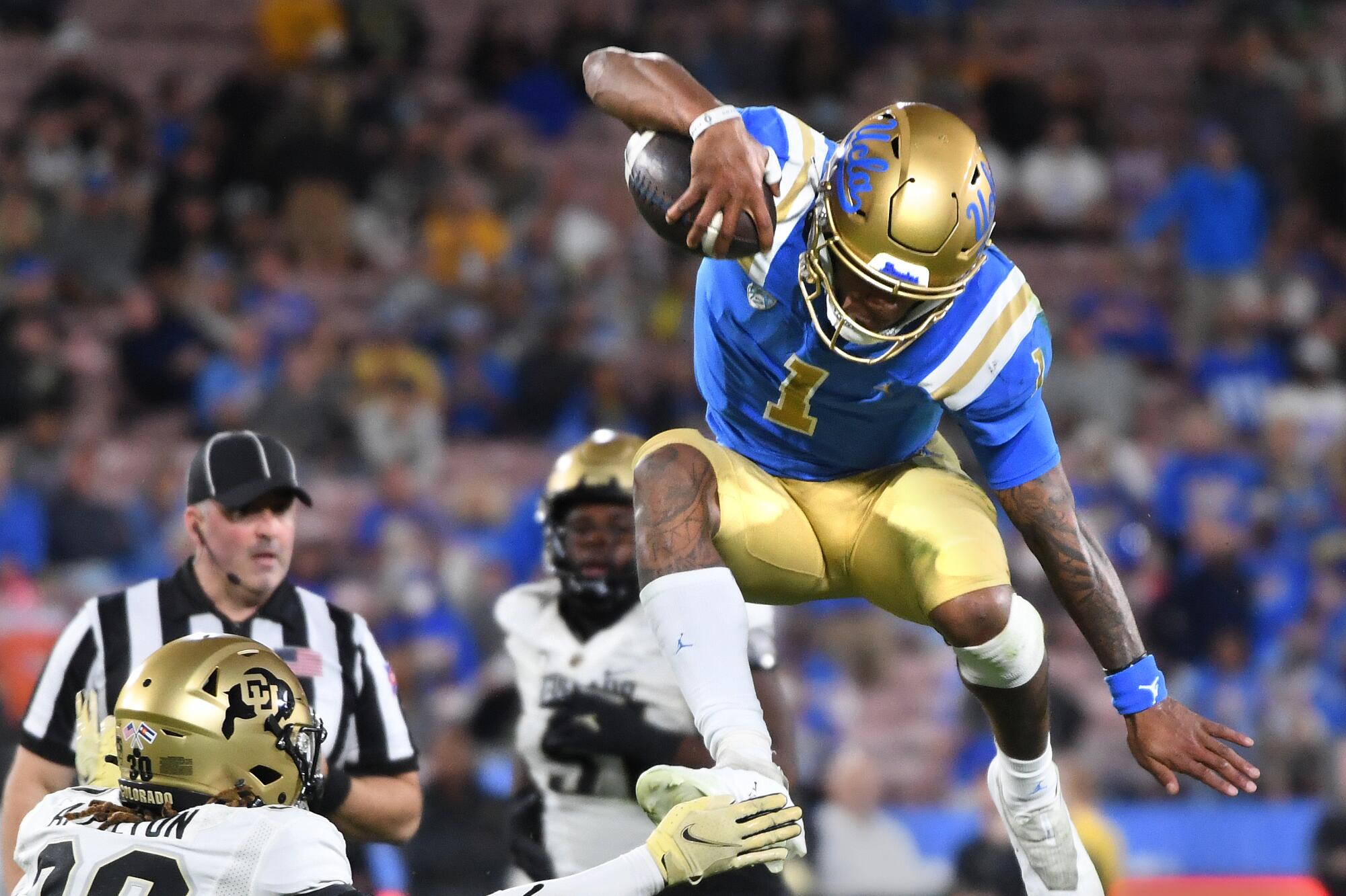 UCLA's Dorian Thompson-Robinson leaps over Colorado's Curtis Appleton and the Bruins are dominating the second half. 