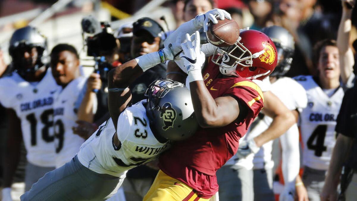 USC receiver Darreus Rogers wrestles the ball away from Colorado's Ahkello Witherspoon.