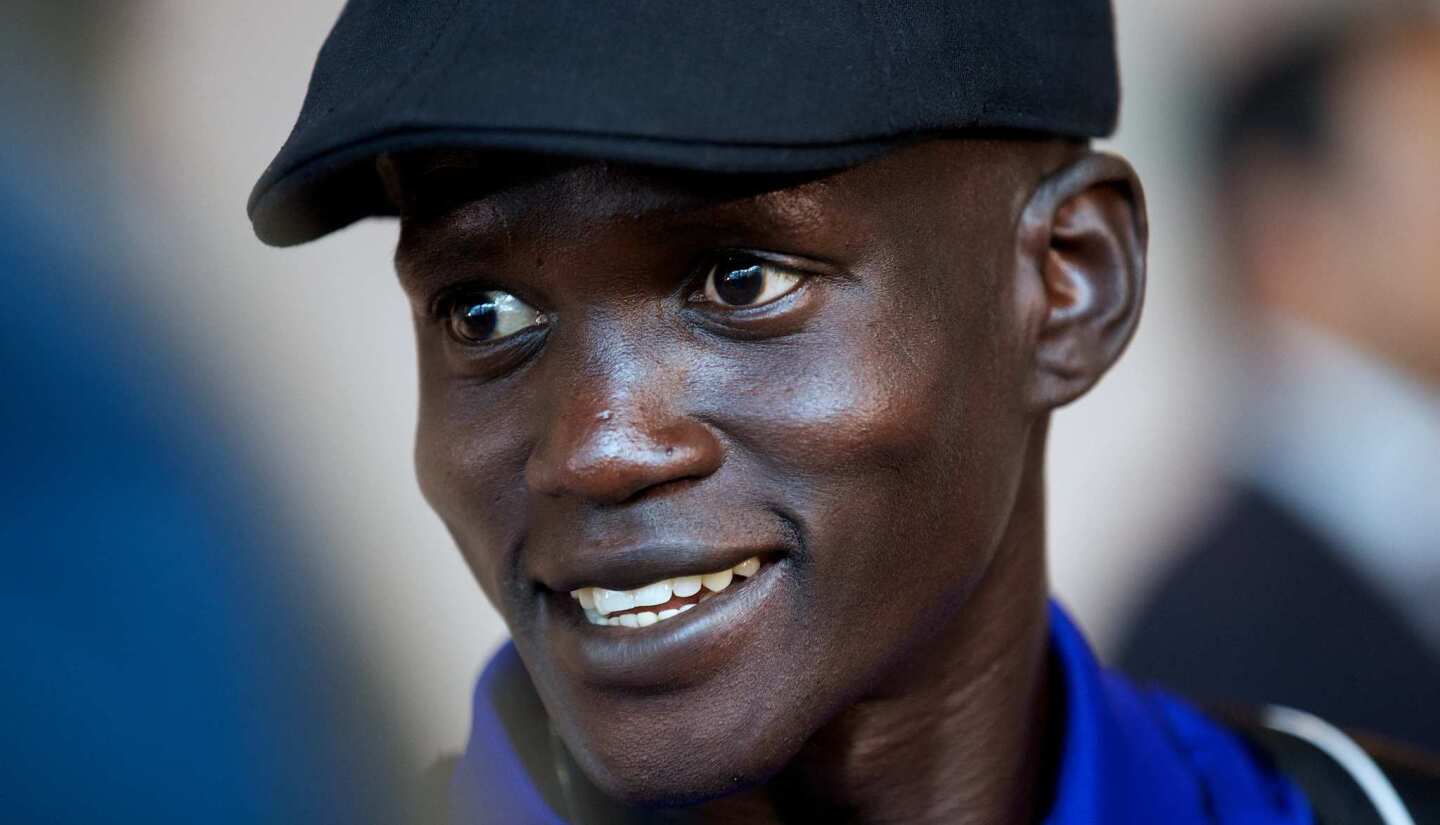 South Sudanese marathon runner Guor Marial smiles as he arrives at Heathrow Airport. His country is the world's newest and does not have an Olympic team, so Marial is competing under the International Olympic Committee flag.