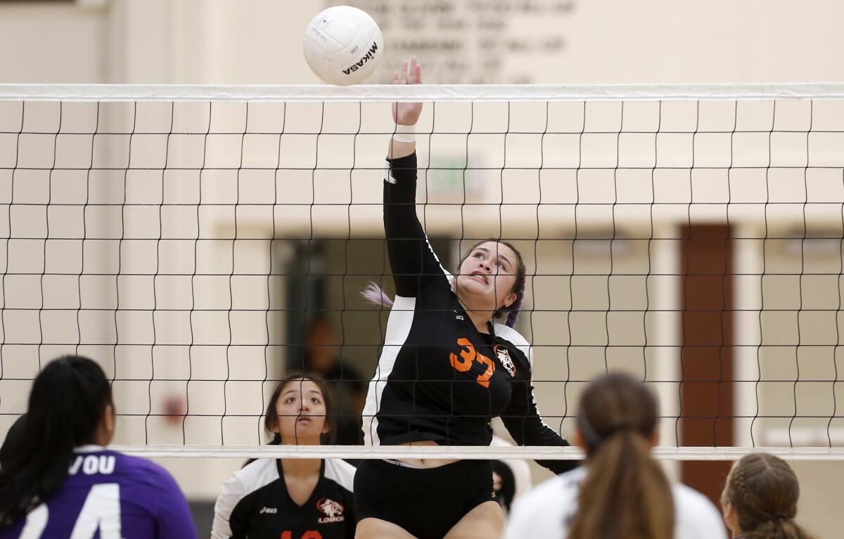 Los Amigos' Rebecca Le spikes the ball against Santiago during the second set of a Garden Grove League match at home Tuesday.