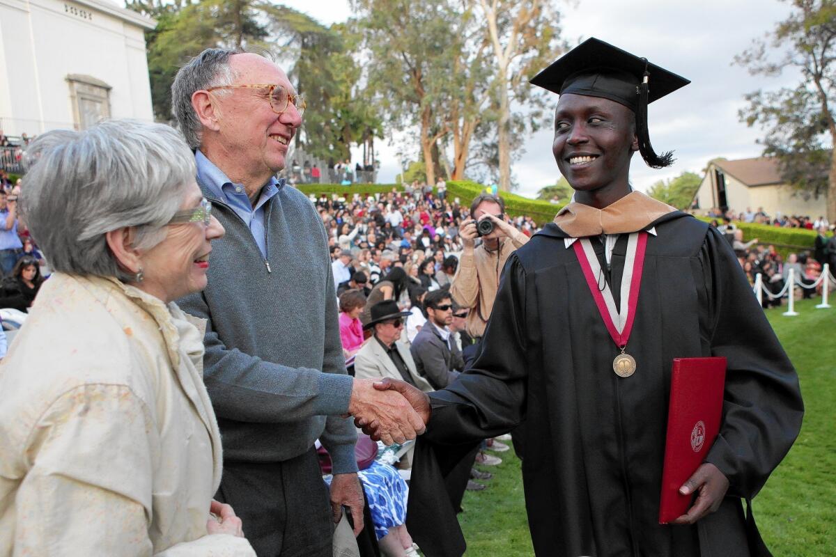 Jack and Laura Dangermond congratulate Patrick Manyika at his graduation from the University of Redlands on Saturday.