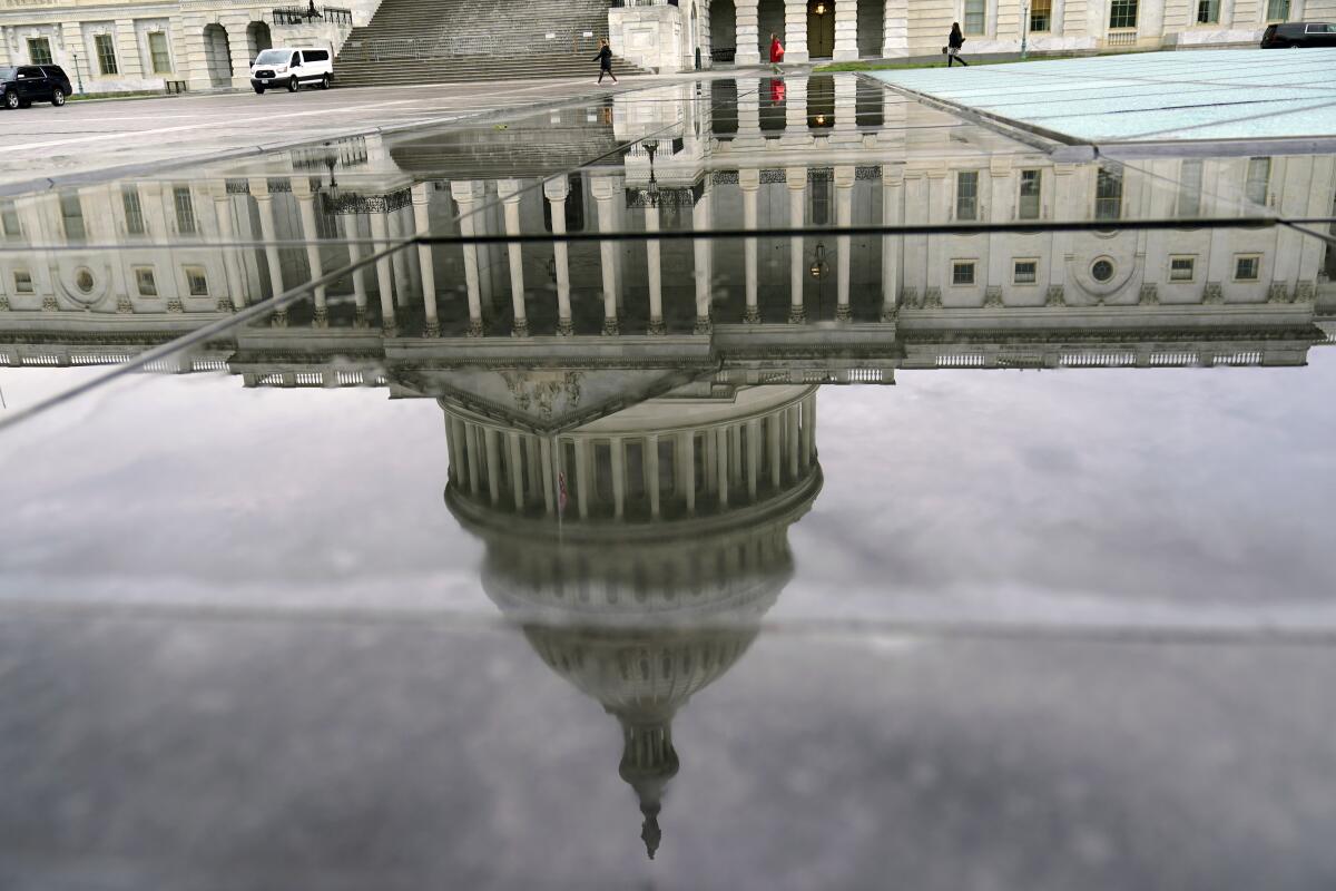 The U.S. Capitol is reflected on a rainy morning.