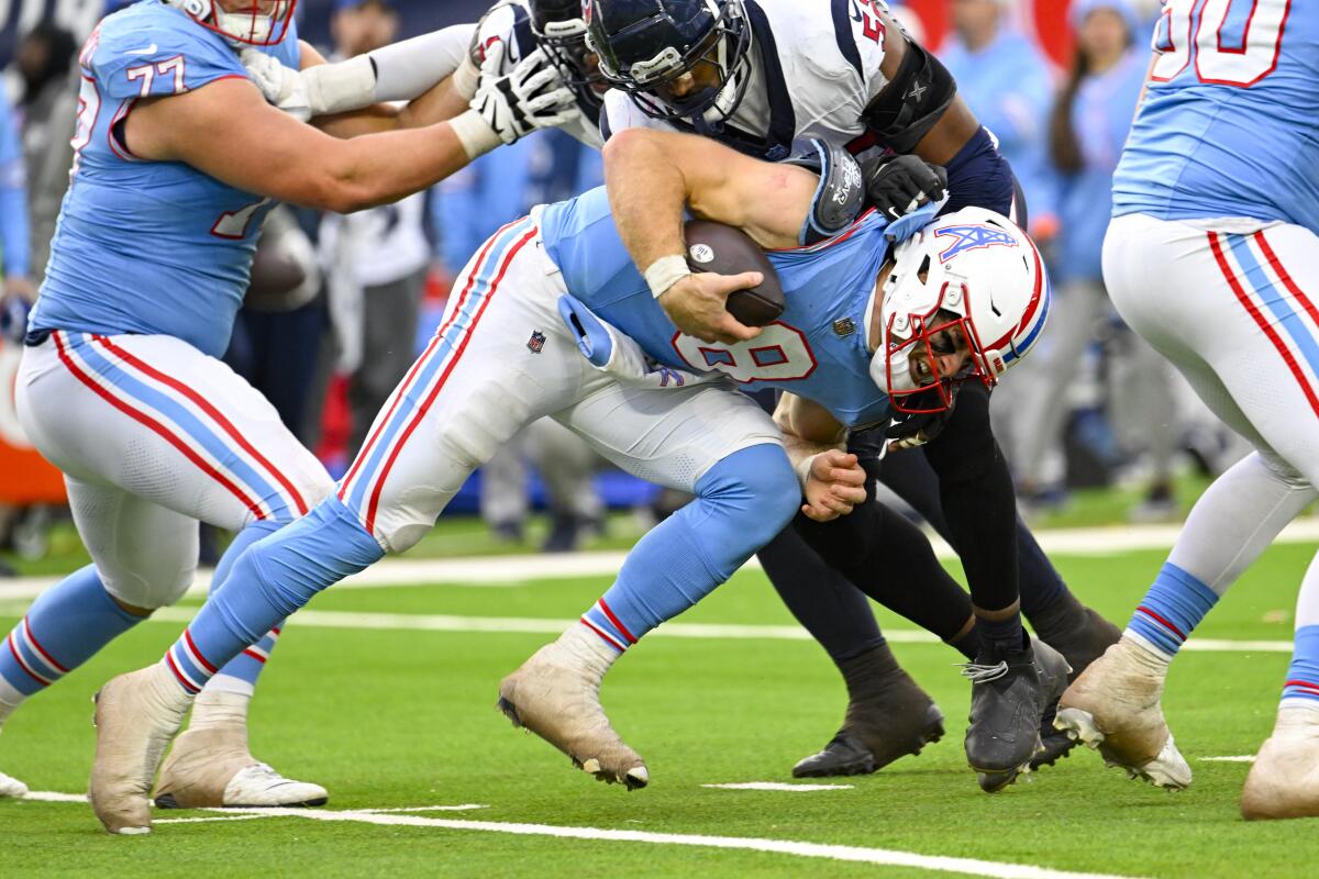 Tennessee Titans quarterback Will Levis (8) is brought down by the Houston Texans.