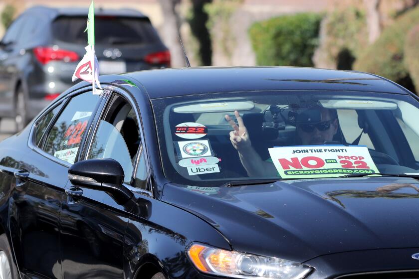 A vehicle with Uber and Lyft stickers arrive at press conference about voting no on proposition 22, in solidarity with Uber and Lyft drivers, at the IBEW headquarters in the city of Orange on Friday, Oct. 16, 2020.