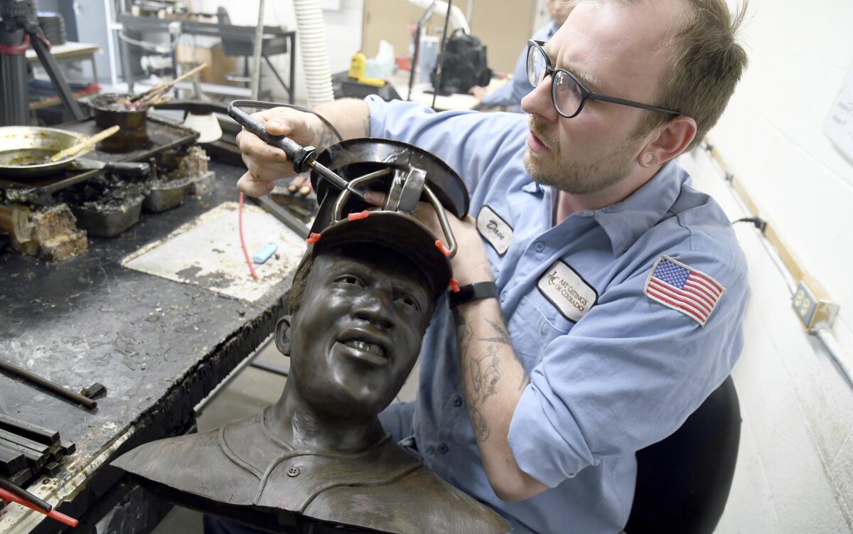 A man works on the bust of Jackie Robinson