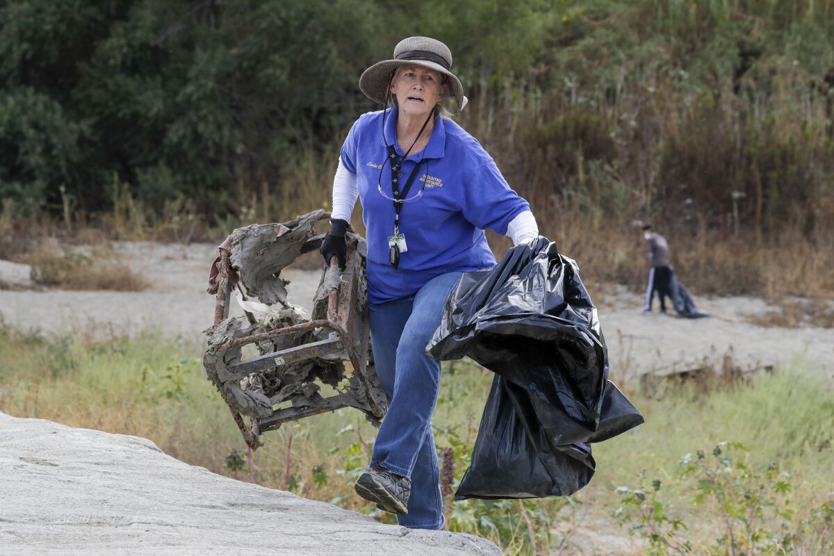 Linda Osborn, 62, a volunteer for Whittier Narrows Park, hauls away trash during the cleanup.