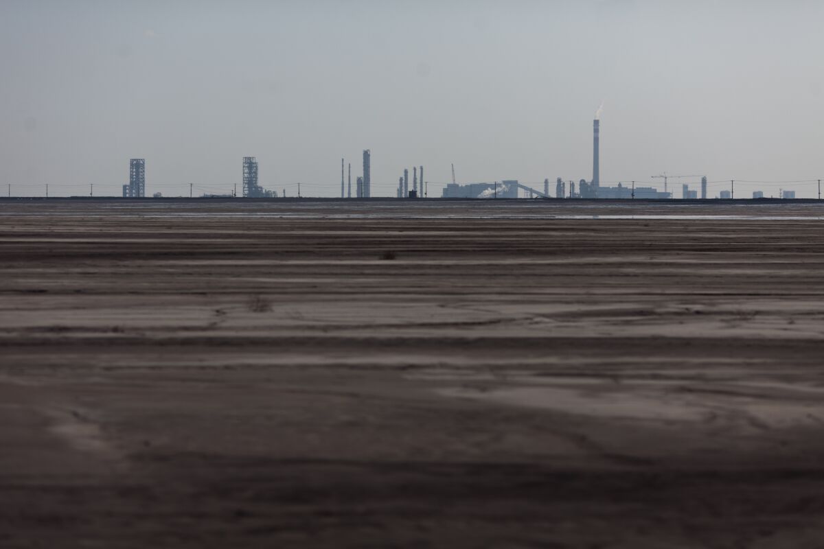 Una foto tomada el 19 de agosto de 2012 muestra una vista general de un lago rodeado de refinerías de tierras raras cerca de la ciudad de Baotou, en Mongolia Interior. En el borde de la ciudad, un lago está ennegrecido por la contaminación de las fábricas que procesan tierras raras.